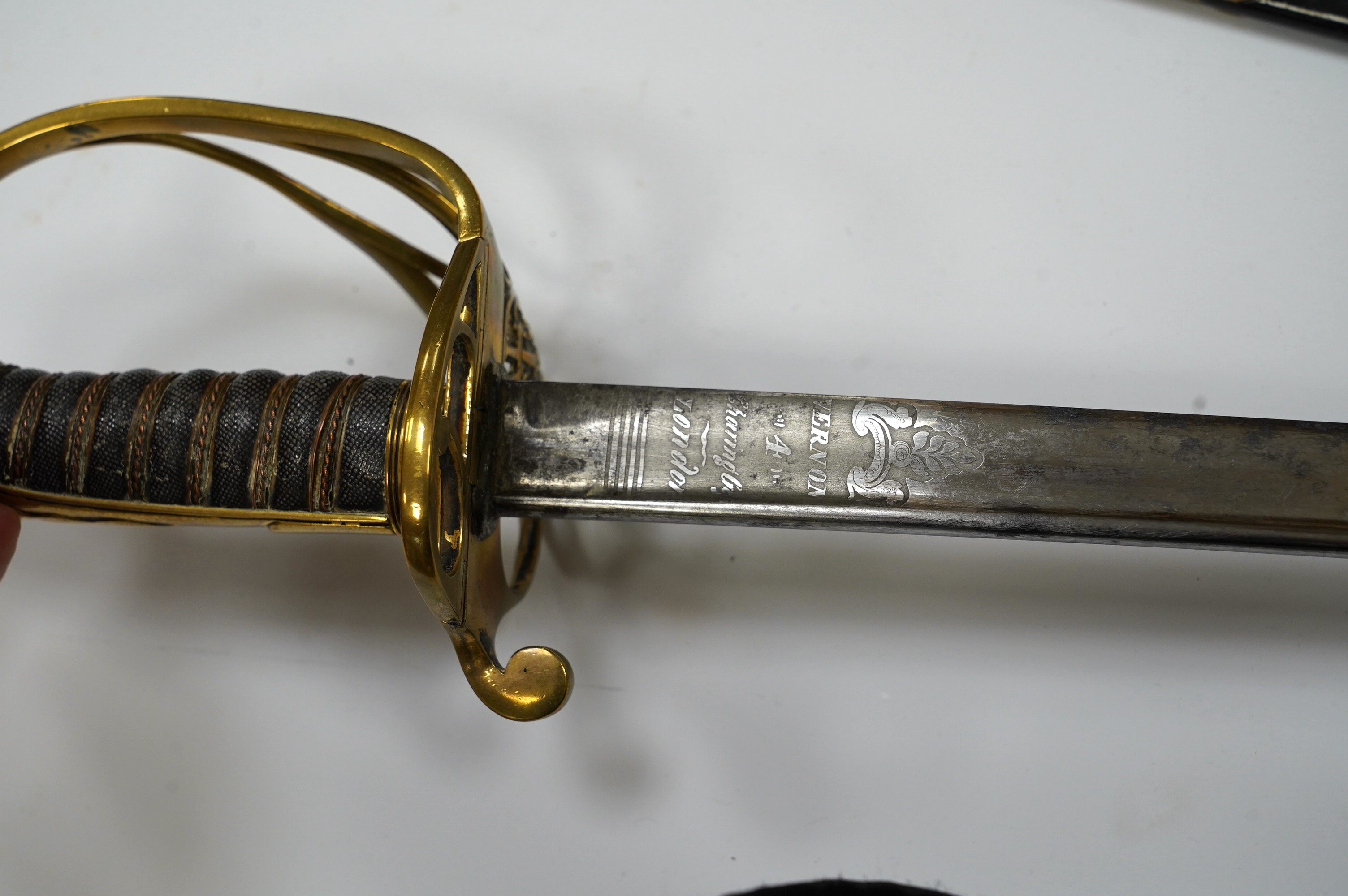 An early 19th century officer's sword, William IV cypher to knuckle guard, folding knuckle guard, engraved curved blade with William IV cypher and makers signature; ‘Vernon 4 Charing Cross London’, leather scabbard with